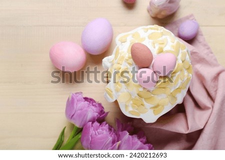 Easter cake, painted eggs and tulip flowers on wooden background