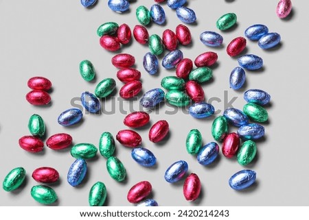 Chocolate Easter eggs in foil on light background