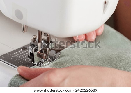 Sewing machine, stitching fabrics, needle in a round plan close up