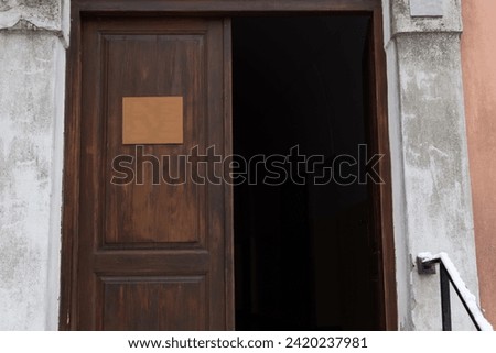 Entrance wooden open door to old house with inscription sign