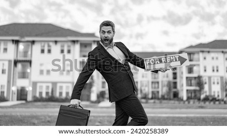 rent property by amazed renter adviser man. renter adviser man hold board for rent sign