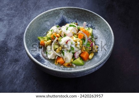 Traditional Peruvian gourmet ceviche sea bass filet piece with sweet potatoes and cancha marinated and served in lime sauce as close-up in a Nordic design bowl 
