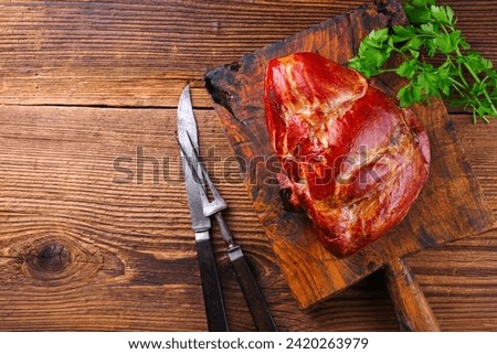Traditional cured and smoked Baden schäufele of pork shoulder served braised with parsley as top view on a rustic metal tray with copy space left