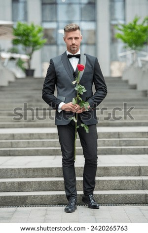 special occasion formalwear. adult man with rose for special occasion. tuxedo man outdoor Royalty-Free Stock Photo #2420265763