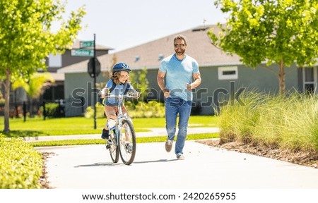 father and son navigate the winding paths together at fatherhood. father and son promenade. father and son in fatherhood. fatherhood of father and son cycling at sunlit park. Cycling duo Royalty-Free Stock Photo #2420265955