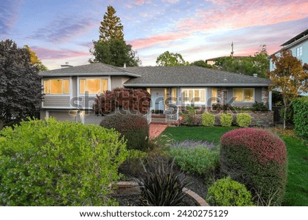 aerial photo of single family house during twilight.  Beautiful landscaping and scenic sky. 