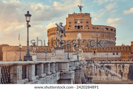 Rome, Italy. Castel Saint Angelo or Mausoleum of Hadrian. Ancient Roman architecture and statues Angels Demons, street lanterns. Sunset view. Royalty-Free Stock Photo #2420284891