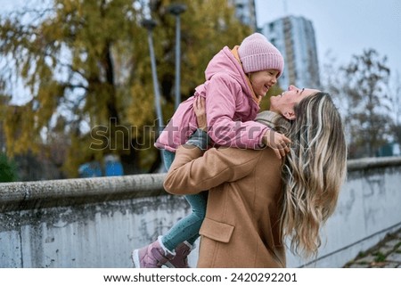A heartwarming scene unfolds as the young mom lifts and embraces her daughter. From the quayside, the little one jumps into her arms, creating precious moments of love and laughter.