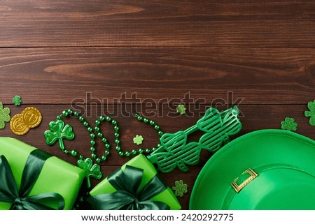 St. Paddy's celebrating: unwrapping a leprechaun's surprise. Top view photo of leprechaun hat, gift boxes, party eyewear, trefoils, coins, beads on wooden background with advert zone