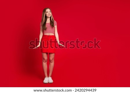 Full length photo of good mood sweet lady dressed striped top mini skirt empty space isolated red color background