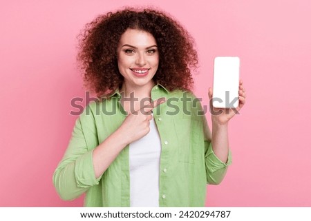 Photo portrait of lovely young lady point hold device white screen wear trendy green garment isolated on pink color background
