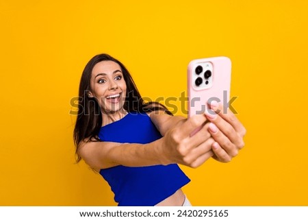 Photo of excited funky lady dressed blue top online chatting apple iphone samsung modern device isolated yellow color background