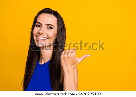 Photo of adorable pretty woman wear blue top showing thumb back empty space isolated yellow color background
