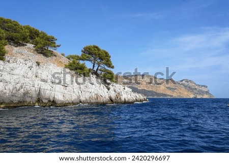 Unique white rocks with caves above the sea surface in the National Park of Calanques in France. View from the sea.
