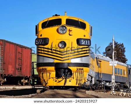 A Streamlined Diesel Electric Locomotive Leading a Passenger Train Royalty-Free Stock Photo #2420315927