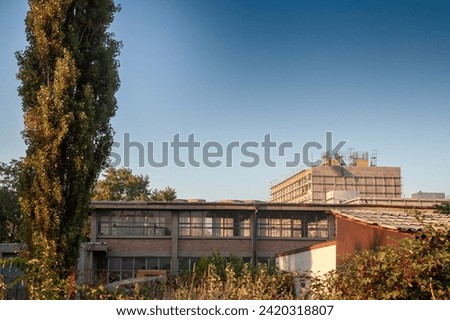 Abandoned factories and warehouses in concrete and red brick, with broken windows and crumbling walls in Eastern Europe, in Belgrade, Serbia, former Yugoslavia. Royalty-Free Stock Photo #2420318807