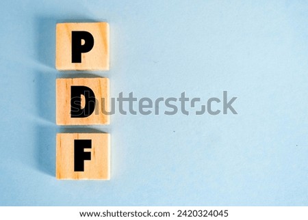 A wooden cube with word “PDF” on it. PDF stands for “Portable Document Format”