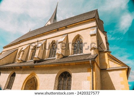 Church of St. Leonard in Austria on a bright blue sky background.Christian and catholic faith. Bottom view . Catholic Church architecture outside.