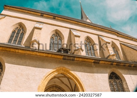  Catholic Church architecture . Church of St. Leonard in Austria on a bright blue sky background. Church building in Gothic style.Christian and catholic faith symbol.Religious symbol.