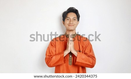 Asian Muslim man with greeting gesture on white background