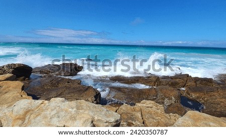 blue sea with under a clear sky with hot sunlight and floating clouds