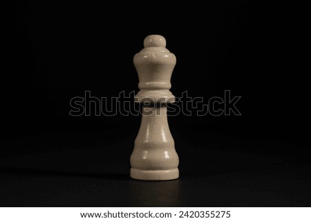 Isolated image of white queen chess piece on black background.