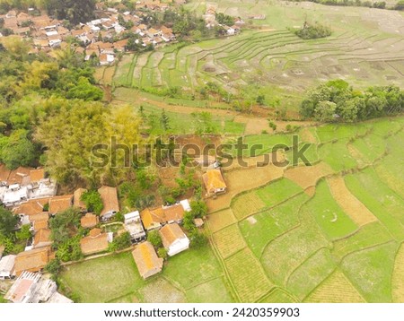 Picturesque patchwork farmland. Aerial Photography. Aerial panorama over idyllic green summer farm fields. Shot from a flying drone. Cikancung, Indonesia