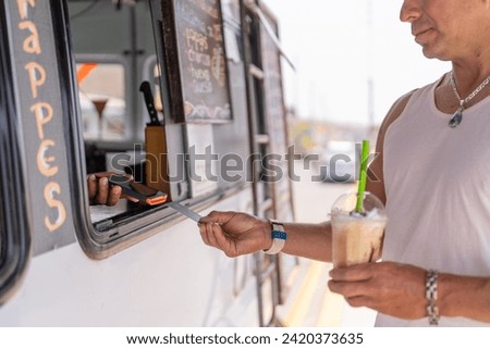 Man paying a take away coffee with credit card in a food truck