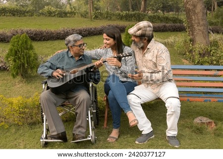 Indian Happy couple helping his father to enjoy the beautiful life with playing guitar and having fun in park