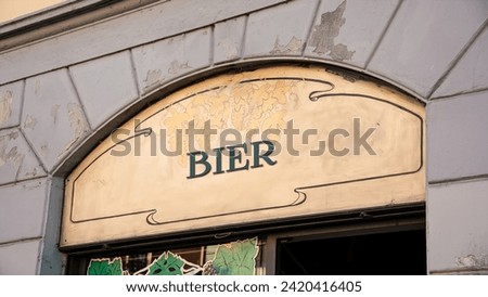the picture shows a signpost and a sign that points in the direction of beer in german.