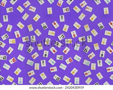 Plastic tiles from the game rummikub, rummicub or  okey in Turkey , scattered and arranged on  purple background, seamless pattern