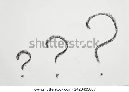 Handwritten question marks in black chalk on a white background. Business concept, doubts, insecurities