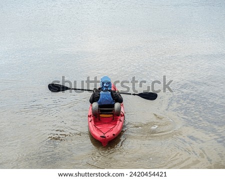 Red Plastic kayak with horizontal paddle Royalty-Free Stock Photo #2420454421
