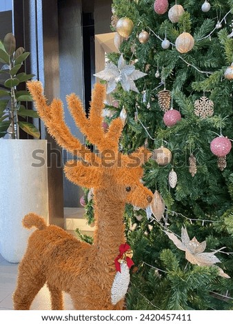 Christmas decoration. Golden deer with Christmas tree
