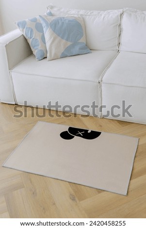 Stylish carpet with a bear pattern. White sofa in the background. Bright interior.