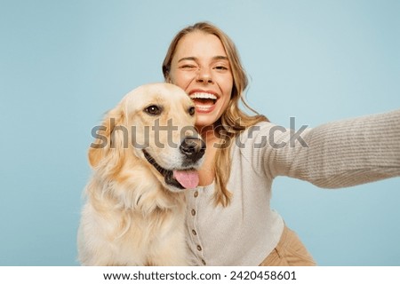 Close up young owner woman with her best friend retriever wears casual clothes do selfie shot on mobile cell phone hug dog isolated on plain pastel light blue background. Take care about pet concept