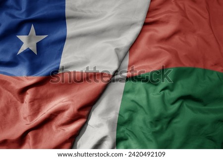 big waving national colorful flag of madagascar and national flag of chile . macro