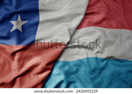 big waving national colorful flag of luxembourg and national flag of chile . macro