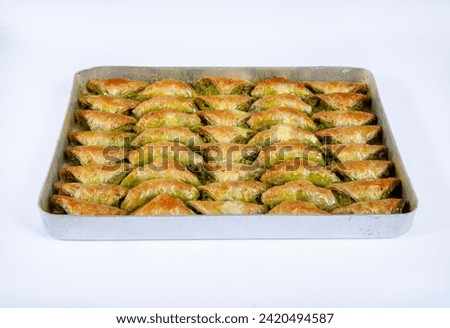 Top view of shaabiyat with pistachio baklava on tray isolated on white background.
