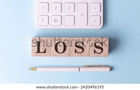 LOSS on a wooden cubes with pen and calculator, financial concept
