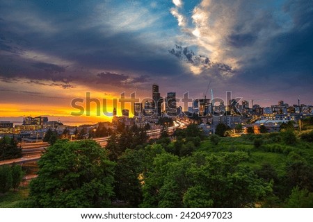 Dramatic sunset over the Seattle skyline, with traffic on the I-5 and I-90 freeway interchange, viewed from Dr. Jose Rizal Bridge.