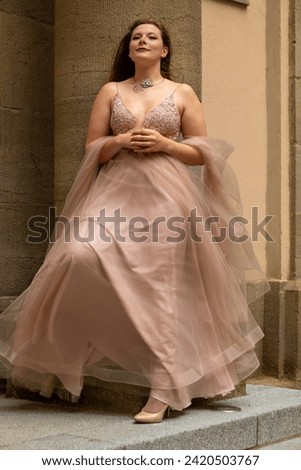 a woman in a beautiful cream colored dress as a princess Royalty-Free Stock Photo #2420503767