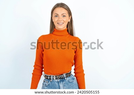 Close up photo of Young beautiful woman standing over white studio background toothy smiling