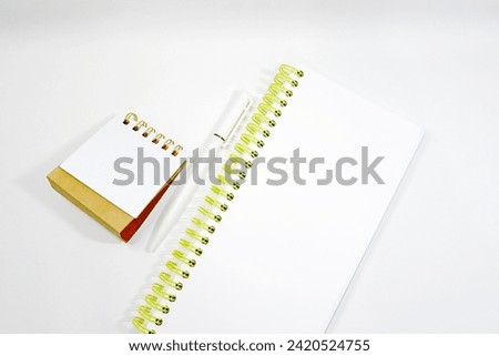 Blank Calendar copy space and yellow looseleaf paper notebook with white pen  foreground on white background diagonal right angle stock photo