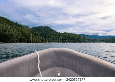 Overlooking front bow of small boat traveling around beautiful remote tropical islands in Bougainville, Papua New Guinea Royalty-Free Stock Photo #2420537177