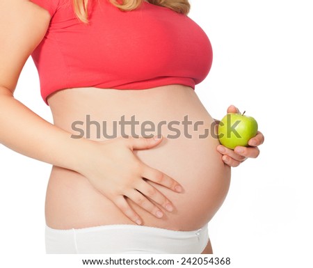 Torso of a pregnant woman with green apple.