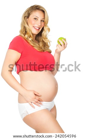 Pregnant woman posing with green Granny Smith apple.