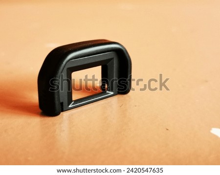 A small black eyecup for the viewfinder of a camera.