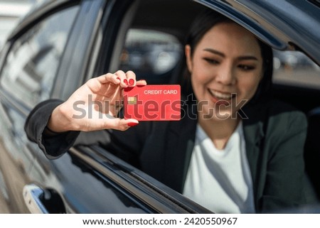 Young beautiful asian business women getting new car. Hand holding credit card payment. Car owner paying fuel pump with credit card customer mileage point loyalty reward. Driving vehicle on the road