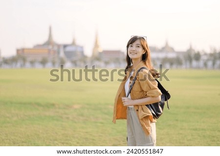 Traveler asian woman 30s exploring Wat Pra Kaew. From stunning architecture to friendly locals, she cherishes every moment, capturing it all in her heart and camera for years to come.